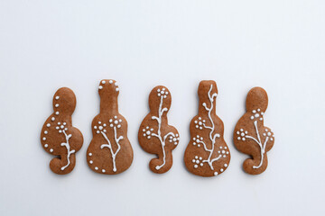Romantic decorated gingerbread cookies in a shape of guitar and treble clef, white background, copy...