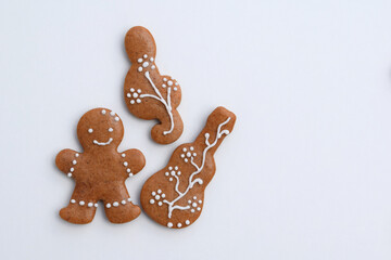 Romantic decorated gingerbread cookies in a shape of guitar, treble clef and man, white background, copy space for text. Musical theme