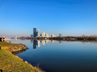 high rise buildings on the edge of the river Danube in Vienna with reflection