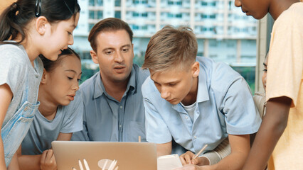 Caucasian teacher giving comment or advise student while smart bot pointing at laptop screen at...
