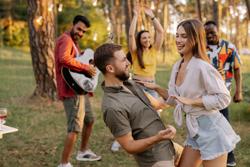 A beautiful couple dancing on the background of friends having fun