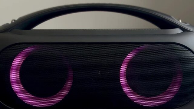 Animation of bright colors of wireless bluetooth speaker on light background. Female hand pressing play pause accept button on portable speaker