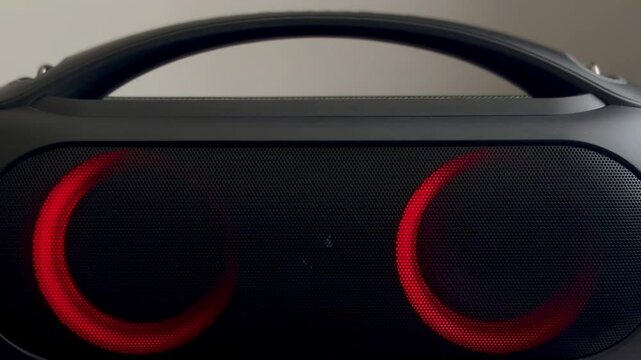 Animation of bright colors of wireless bluetooth speaker on light background. Female hand pressing play pause accept button on portable speaker