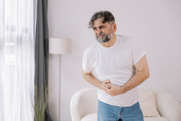 Elderly man suffering from digestive problems, liver and gall bladder problems and intestinal pain...