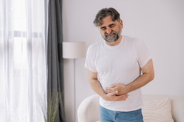 Elderly man suffering from digestive problems, liver and gall bladder problems and intestinal pain...