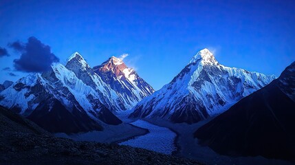A beautiful night view of the Himalayas, snow-capped mountains with a dark blue sky and some clouds 