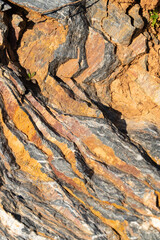 The background is a beautiful rough stone texture in close-up with bright colors of mineral inclusions