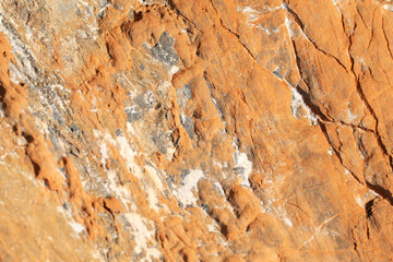 The background is a beautiful rough stone texture in close-up with bright colors of mineral...