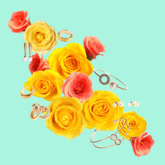 Shiny bijouterie and beautiful flowers air on light blue background