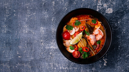 Delicious homemade fish and seafood soup with vegetables and tomatoes. Served in a round bowl.