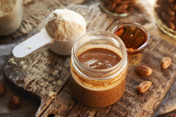 Homemade hazelnut butter, whey protein powder and maple syrup - ingredients for healthy protein snack bars