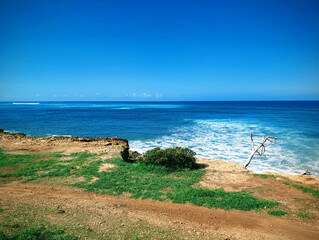 Explore the serene coastline of Oahu, Hawaii, featuring turquoise waters and lush green landscapes under a clear blue sky