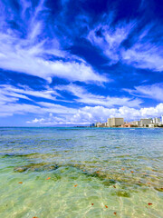 Stunning view of Waikiki Beach and clear waters of Oahu during a sunny day with vibrant clouds above