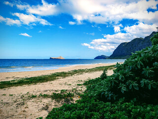 Waimanalo Beach on Oahu showcases pristine sands and crystal blue waters under a vibrant sky filled with clouds