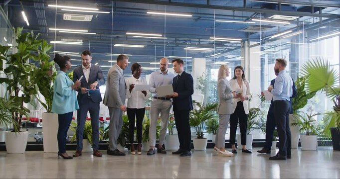 Modern office diverse businesspeople, multiracial colleagues talking in small groups, discuss ideas before team meeting, busy multiethnic people speak to brainstorm, cooperate chat at workplace