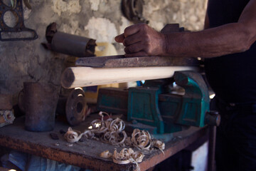 Close up of a carpenter planing a plank of wood with a hand plane