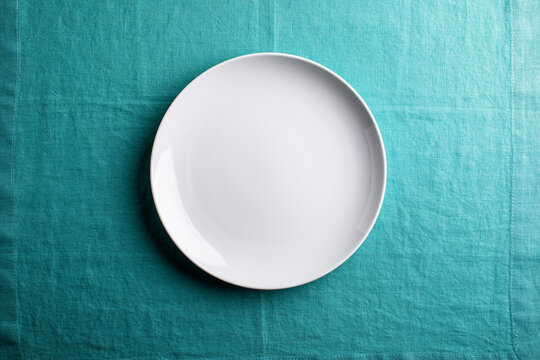 white plate on aqua linen , overhead