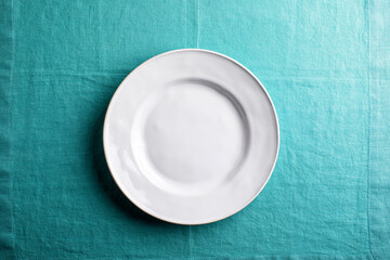 white plate on aqua linen , overhead