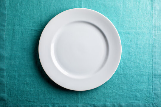 white plate on aqua linen , overhead