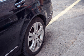 Close the front wheel of a car on an asphalt road