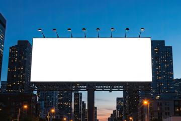 Obraz premium Large illuminated blank billboard in a city at dusk.
