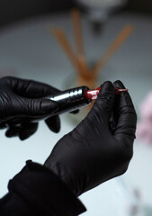 The artist inserts a cartridge into an eyebrow tattoo machine