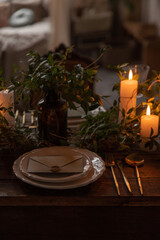 Table setting with plate, envelope and candles