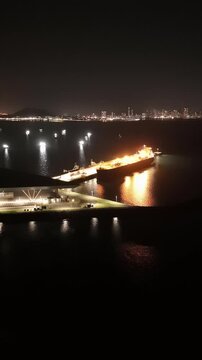 Cinematic aerial view from a drone at night on the Amador Causeway in Panama City, Vertical 4K Video