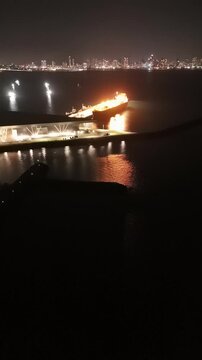 Cinematic aerial view from a drone at night on the Amador Causeway in Panama City, Vertical 4K Video