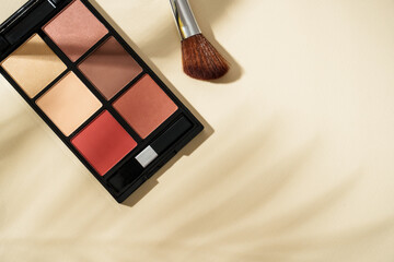 Make up products at colored background with hard shadows.