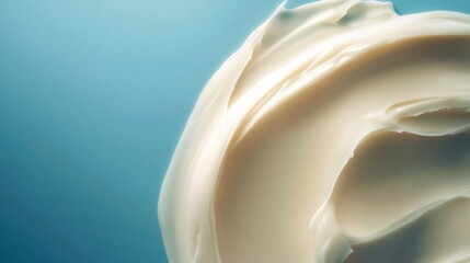 Creamy face moisturizer swirled on light teal background
