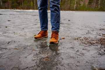 Person walking carefully on thin ice across a frozen lake, winter landscape, risky adventure, caution in nature