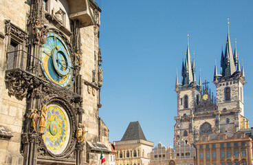Obraz premium The historic Old Town Hall with its astronomical clock mounted on its side and the Gothic Church of our Lady before Týn, tower over Old Town Square in Prague, Czech Republic on a summer day.