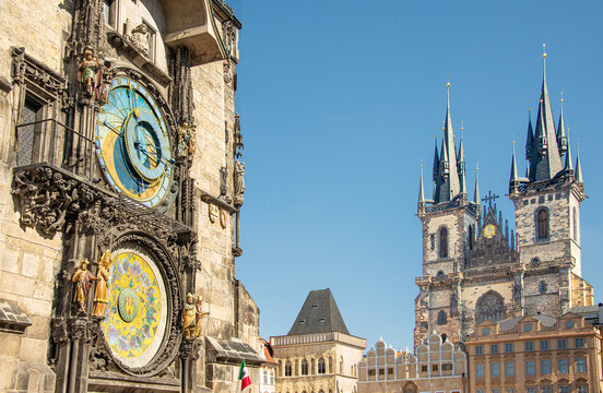 The historic Old Town Hall with its astronomical clock mounted on its side and the Gothic Church of our Lady before Týn,  tower over Old Town Square in Prague, Czech Republic on a summer day. - Powered by Adobe