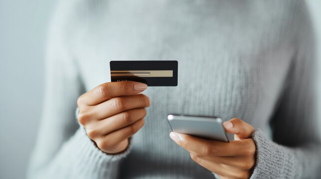Smartphone shopping with credit card in hand.
