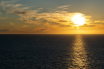 Beautiful sunset with great cloudscape over the Pacific and the reflection of the sun in the sea.