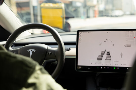 Porto, Portugal - 07.10.2024: Dashboard electric car TESLA Model 3. Interior dashboard with modern interface design and steering wheel decoration.