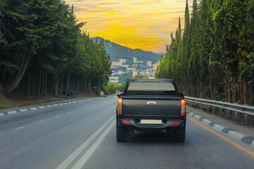 pickup truck drives along a country road into a town