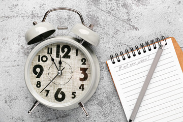 Notebook with text IF NOT NOW, WHEN? and alarm clock on grey background. Time management concept....