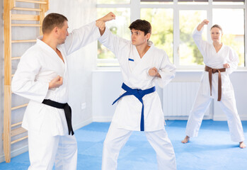 Two men practicing punches during karate classes in the gym