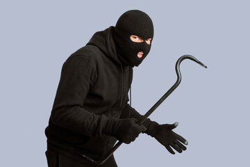 Cat Burglar Concept. Portrait of sneaky masked criminal holding crowbar, copy space, isolated over white studio wall