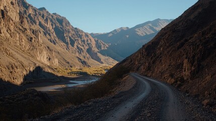 Winding mountain road overlooking a valley river.