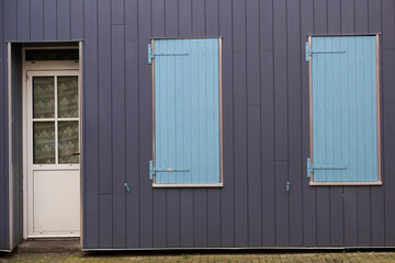 A dilapidated structure with a solitary door and boardedup windows, conveying a sense of abandonment
