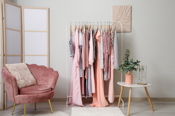 Interior of boutique with clothes rack, armchair and folding screen
