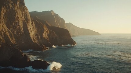Naklejka premium Majestic coastal cliffs at sunset, ocean waves crashing against rocky shores.