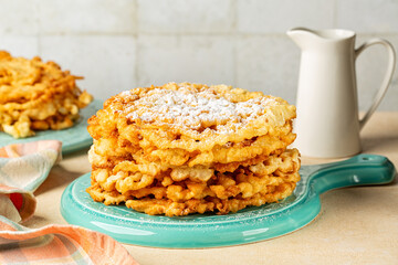 Breakfast with Carnival Funnel cake. American sweet food made by pouring batter through a funnel into hot cooking oil in a circular pattern and deep frying. Served  with powdered sugar. 