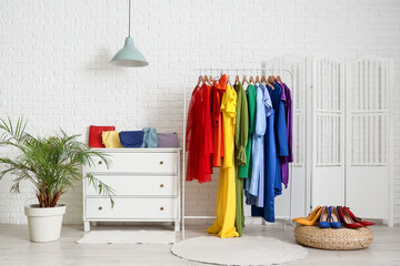 Interior of boutique with colorful clothes, bags and shoes