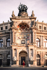 Obraz premium Elegant wide-angle shot of the Semperoper opera house in Dresden, Germany, during twilight. The historic architecture is illuminated by warm interior lights against a soft pastel sky.