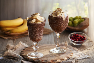 Two cups of healthy chia chocolate pudding with fresh bananas