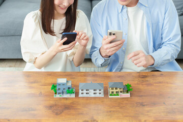 スマートフォンで不動産を探す夫婦
